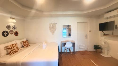 a bedroom with a bed and a table and a television at Apache Loongdum Koh Samed in Ko Samed