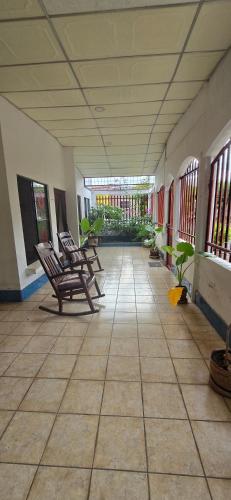 a hallway with rocking chairs in a building at Pequeña Havana in Managua