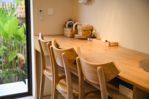 a wooden table with four chairs at a counter at Kedungu Village by Hello Summer in Tabanan