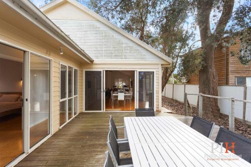 a deck with a table and chairs on a house at Family Home Silverleaves Sleeps 12 in Rhyll