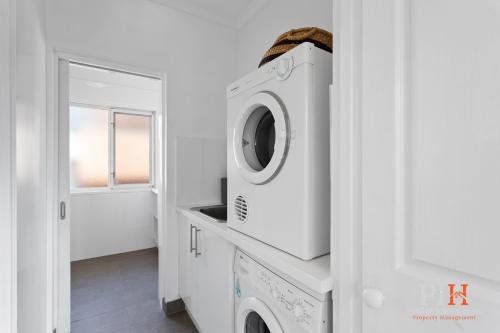 a white laundry room with a washer and dryer at Family Home Silverleaves Sleeps 12 in Rhyll