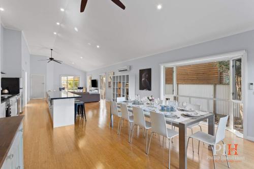 a dining room and kitchen with a table and chairs at Family Home Silverleaves Sleeps 12 in Rhyll