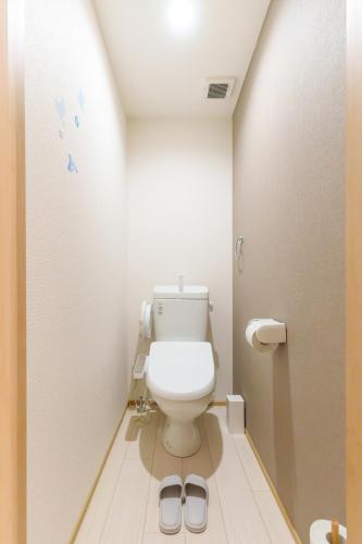 a bathroom with a toilet with a pair of slippers at Sion OSU in Nagoya