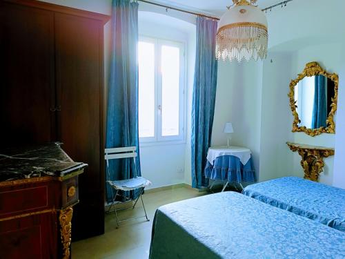 une chambre avec deux lits, un miroir et une fenêtre dans l'établissement VILLA MONICA Diano San Pietro (IM) Italy, à Diano San Pietro