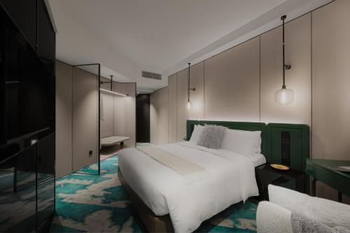a bedroom with a large bed with a green headboard at The Harbourview - Chinese YMCA of Hong Kong in Hong Kong