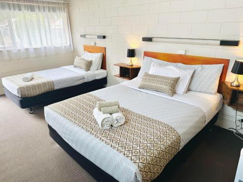 a bedroom with two beds with towels on them at Tartan Motel in Yea