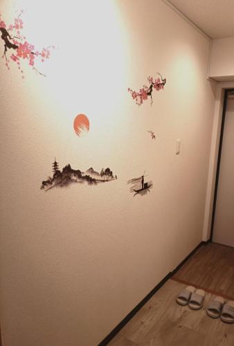 a wall with a drawing of a person on a boat at SN3A 大須徒歩10分 TV,パソコンなど設備充実 木の温もりあるナチュラルな部屋 8人可 10-minute walk to Osu Fully equipped with TV, PC, etc Natural wooden warm rooms Accommodates 8 people in Nagoya