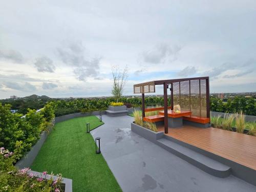 a garden with a wooden deck and a lawn at คอนโดอีสวิลบางแสน ห้อง 7 in Ban Hua Khao Sammuk