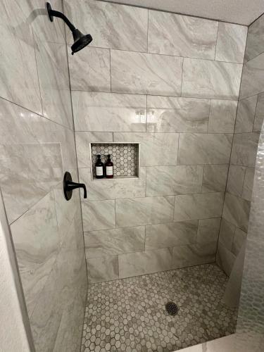 a shower with a glass door in a bathroom at 4BR Modern Getaway by Lackland & SeaWorld in San Antonio