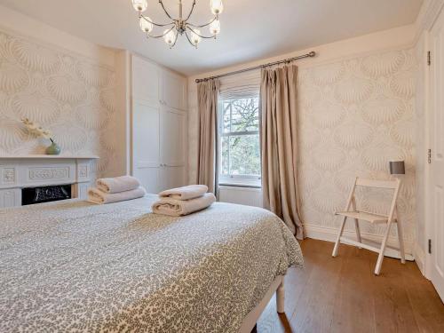 a bedroom with a bed with towels on it at 3 Bed in Brockenhurst NFL92 in Brockenhurst