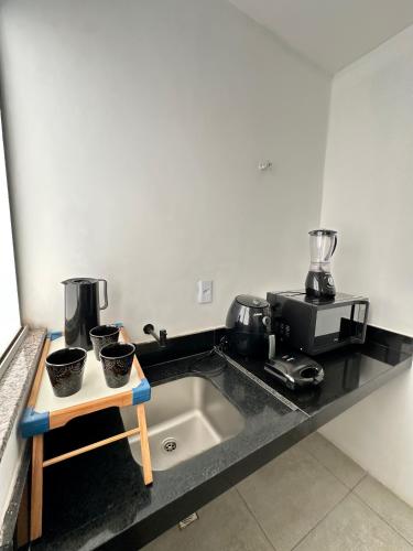 a kitchen sink with three pots on a counter at Apartamento Próximo ao Aeroporto e Rodoviária in Palmas