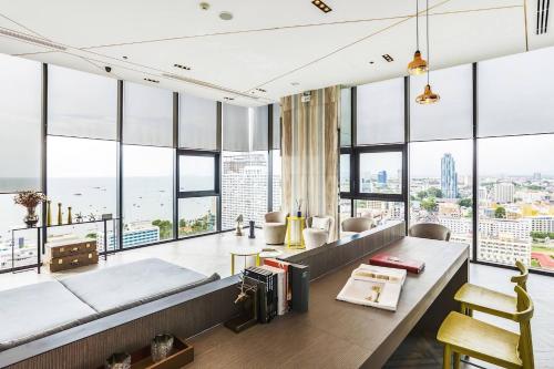 パタヤ・セントラルにあるExcellent Location - Condo Infinity Pool Pattayaの大きな窓とソファのあるリビングルーム