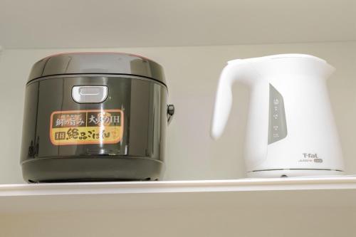 a slow cooker and a toaster on a shelf at Villa NIRAI in Uruma