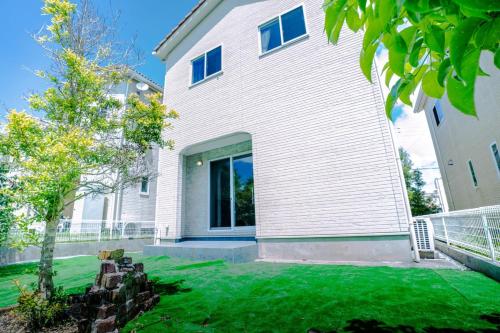 a large white house with a yard at Villa NIRAI in Uruma