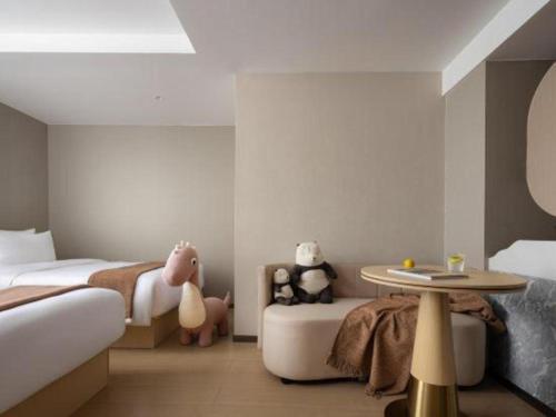 a bedroom with two beds and a table with stuffed animals at Immersing Hotel Guilin Two Rivers and Four Lakes Dongxi Alley in Guilin