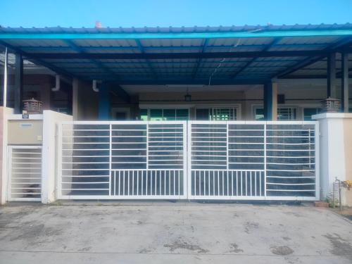 a white gate in front of a house at Stingless Bee Homestay in Kluang