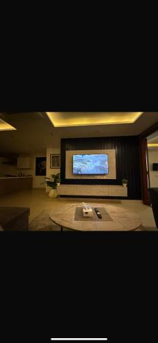 a living room with a flat screen tv on a wall at Gold Crest Apartments Luxurious in Lahore