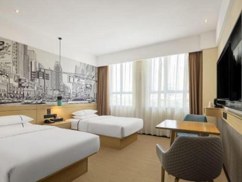 een hotelkamer met twee bedden en een bureau bij City Comfort Inn Liuzhou Gubu Street Ma'anshan Park in Liuzhou