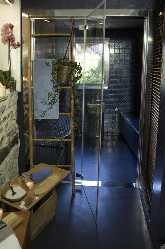 a bathroom with a glass shower and a table at WUNDERGARTEN Dimora dei Frati in Gratteri