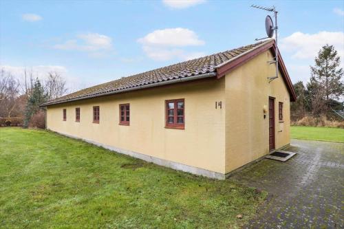 a small yellow building in a field with a yard at 20145-Samso-Skovvejen-14 in Nordby