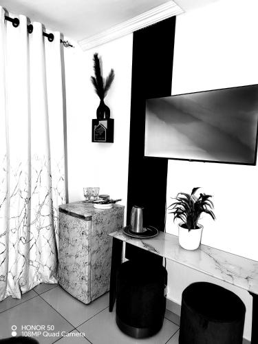 a room with a table and two stools and a plant at Palma spaces in Pretoria