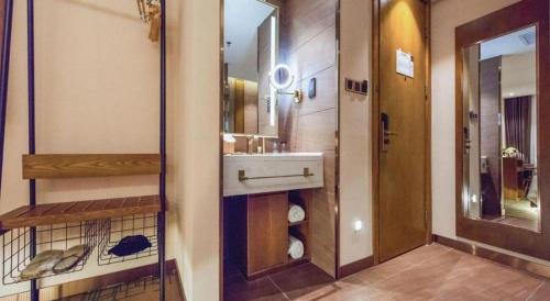 a bathroom with a sink and a mirror at James Joyce Coffetel Changchun People's Square in Changchun