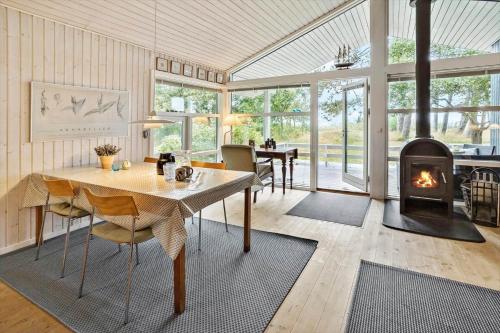 a living room with a table and a fireplace at 20311-Samso-Havvejen-87 in Sælvig