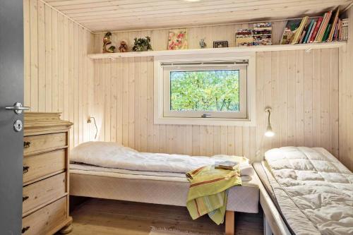 a small bedroom with two beds and a window at 20311-Samso-Havvejen-87 in Sælvig