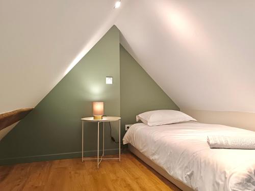 a bedroom with two beds and a table with a lamp at La Bullote - Gîtes - Paris Roissy CDG in Villeneuve-sous-Dammartin