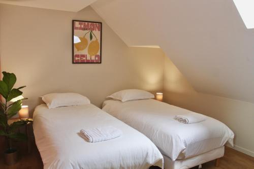 two beds sitting next to each other in a room at La Bullote - Gîtes - Paris Roissy CDG in Villeneuve-sous-Dammartin