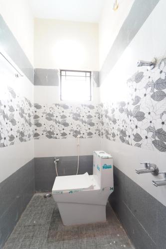 a bathroom with a toilet and a sink at Medhaa Homes Madurai in Madurai