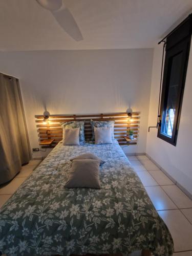 Un dormitorio con una cama grande con una almohada. en La Terrasse de Ugo, en Saint-Pierre