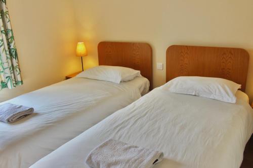 two beds sitting next to each other in a room at La Bullote - Gîtes - Paris Roissy CDG in Villeneuve-sous-Dammartin