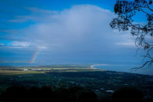a rainbow in the sky over the ocean at Mount Rumney Escapes - 4 Seaview Devil House in Mount Rumney