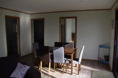 a living room with a dining room table and chairs at Mount Rumney Escapes - 4 Seaview Devil House in Mount Rumney