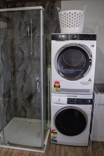 a washer and dryer next to a shower at Mount Rumney Escapes - 4 Seaview Devil House in Mount Rumney