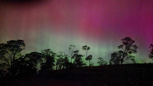 a rainbow in the sky with trees in the foreground at Mount Rumney Escapes - 5 Seaview Kangaroo House in Mount Rumney