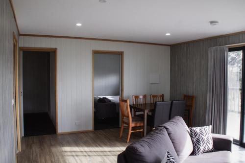 a living room with a couch and a table at Mount Rumney Escapes - 5 Seaview Kangaroo House in Mount Rumney