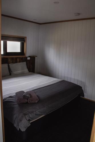 a bedroom with a bed with a towel on it at Mount Rumney Escapes - 5 Seaview Kangaroo House in Mount Rumney