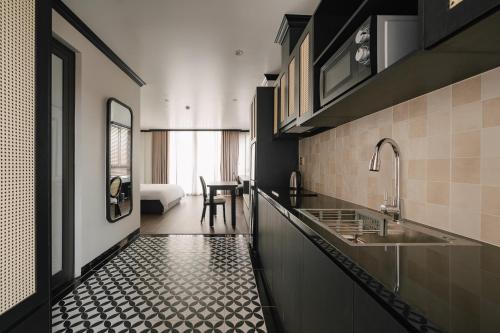 a kitchen with a black and white tile floor at Dom's Residence Hoan Kiem in Hanoi