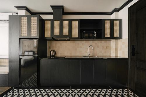 a kitchen with black cabinets and a sink at Dom's Residence Hoan Kiem in Hanoi
