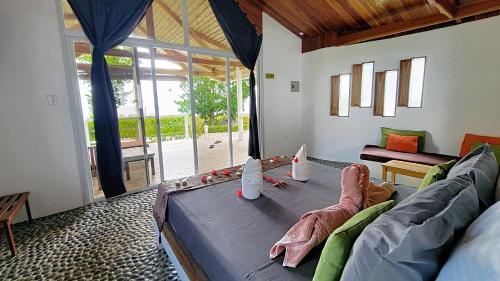 圣胡安Kawayan Holiday Resort的带沙发和大窗户的客厅