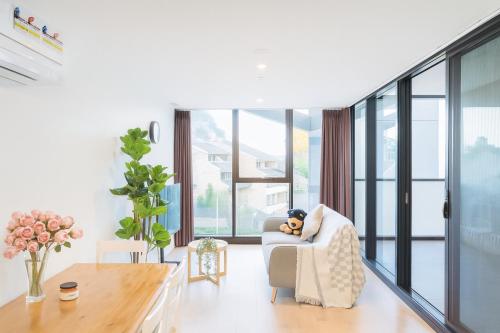 a teddy bear sitting in a chair in a living room at Easeful Canberra CBD 2BR Apt in Canberra