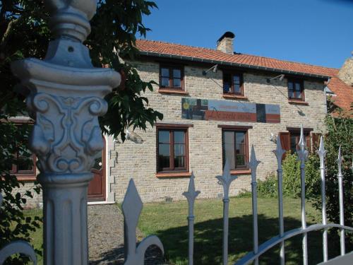 a fence in front of a stone building at Holiday Home in Alveringem near Coast in Leisele