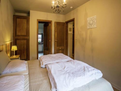 a bedroom with two beds and a chandelier at Holiday Home in Alveringem near Coast in Leisele