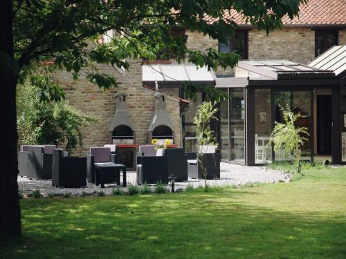 a garden with tables and chairs in front of a building at Holiday Home in Alveringem near Coast in Leisele