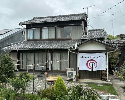 a house with a sign on the front of it at 昭和神ヶ谷ハウス in Hamamatsu