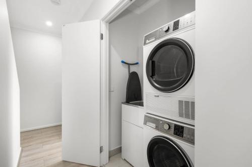 a laundry room with a washer and dryer at Cherry St Retreat Armstrong Creek in Marshalltown