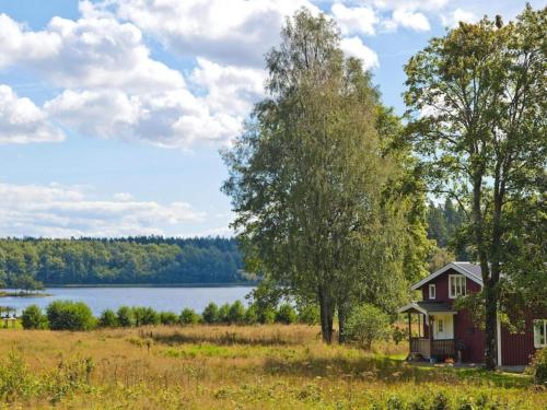 a small house in a field next to a lake at 6 person holiday home in Brålanda-By Traum in Brålanda