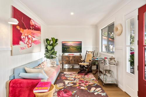 a living room with a couch and a red rug at Lady Rose Cottage Jamberoo in Jamberoo